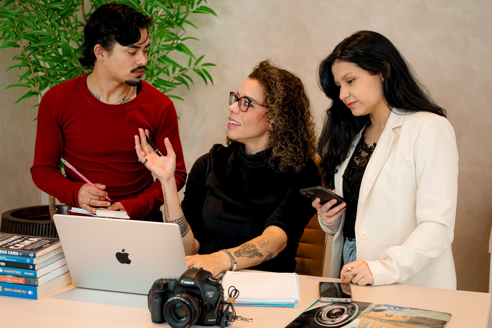 Time da Pinha Criativa reunido em volta de um notebook, trabalhando em ideias